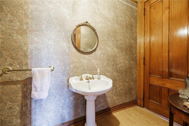 bathroom with baseboards and wood finished floors