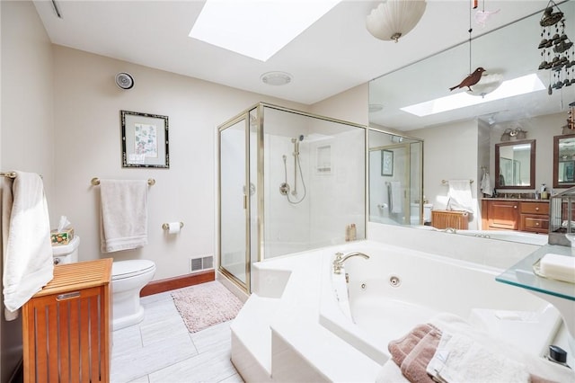 full bath featuring toilet, a whirlpool tub, a shower stall, a skylight, and visible vents
