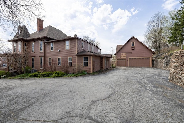 exterior space featuring a chimney and a garage