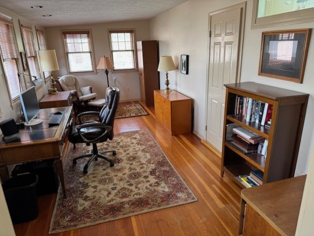 office space with light wood-style floors and a textured ceiling