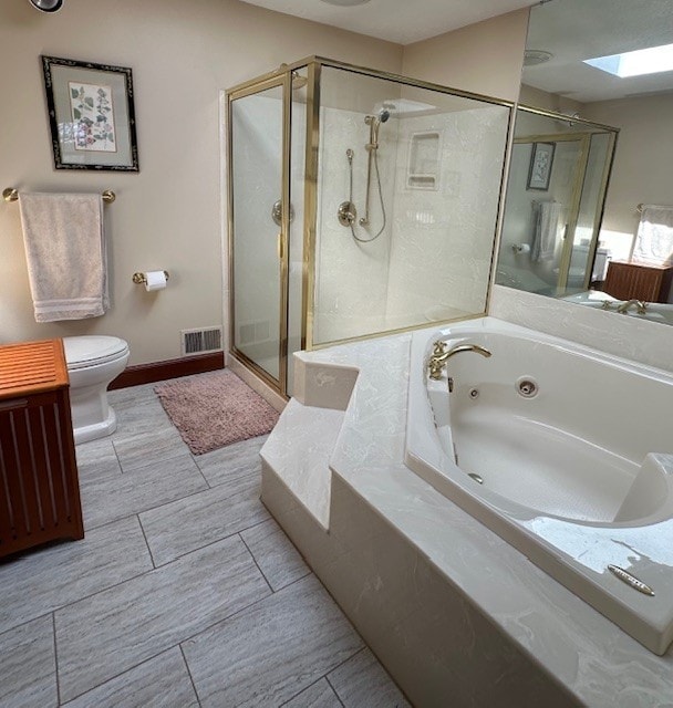 full bath with a jetted tub, visible vents, a skylight, a shower stall, and toilet