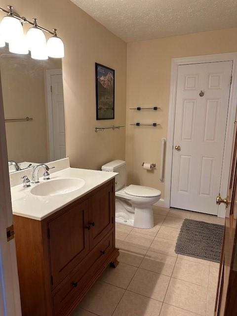 bathroom featuring tile patterned flooring, a textured ceiling, toilet, and vanity