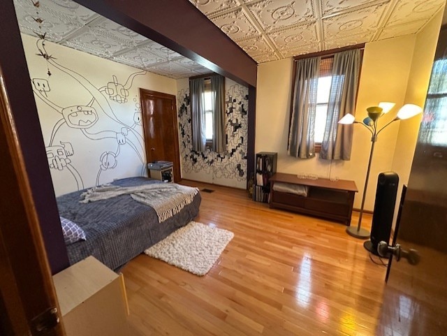 bedroom with an ornate ceiling and wood finished floors