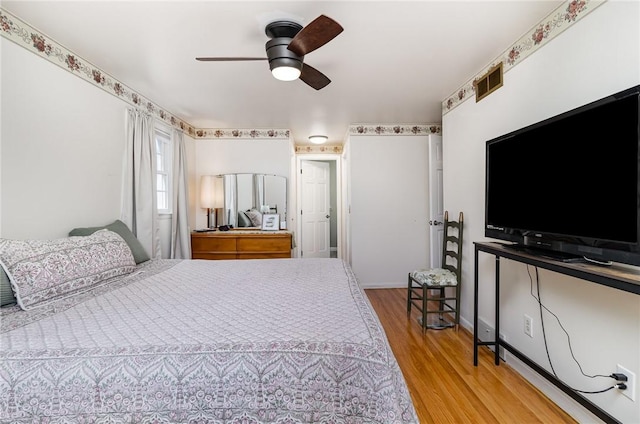 bedroom with visible vents, light wood finished floors, and ceiling fan