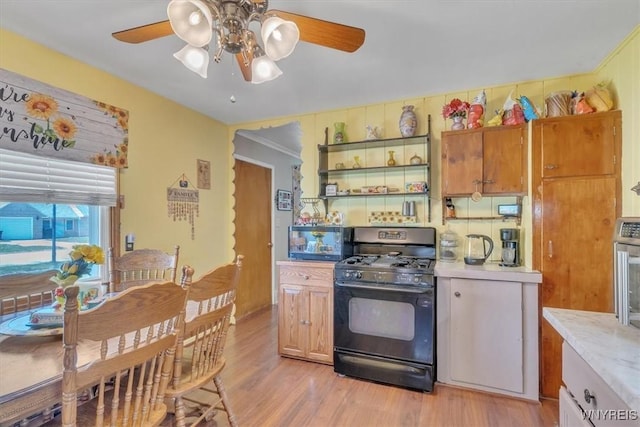 kitchen featuring open shelves, black range with gas stovetop, ceiling fan, light countertops, and light wood-style flooring