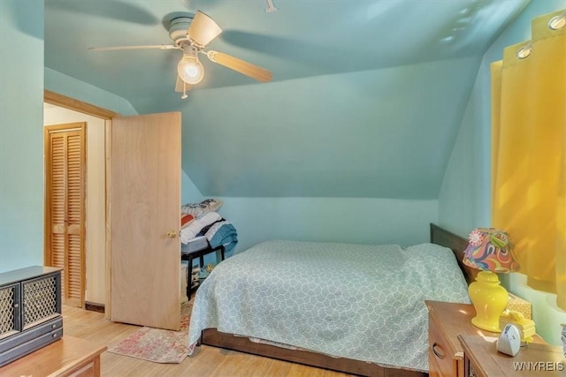 bedroom with a ceiling fan, vaulted ceiling, and wood finished floors