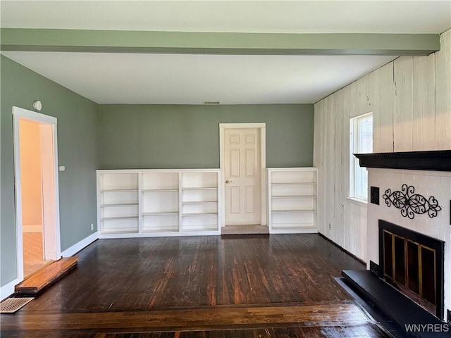 unfurnished living room with baseboards, dark wood-style flooring, a brick fireplace, and visible vents