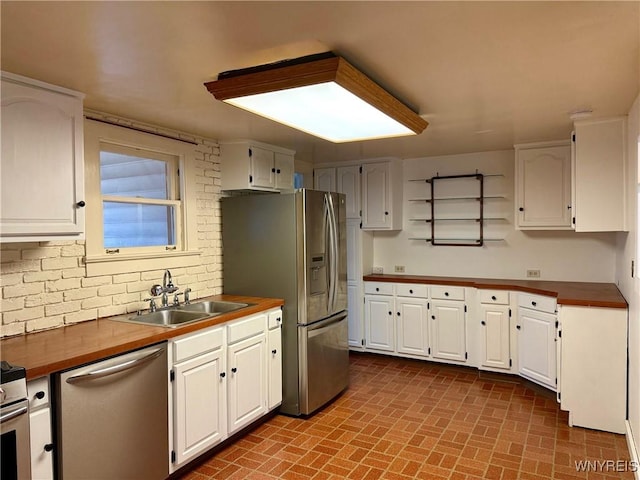kitchen with a sink, appliances with stainless steel finishes, and white cabinetry