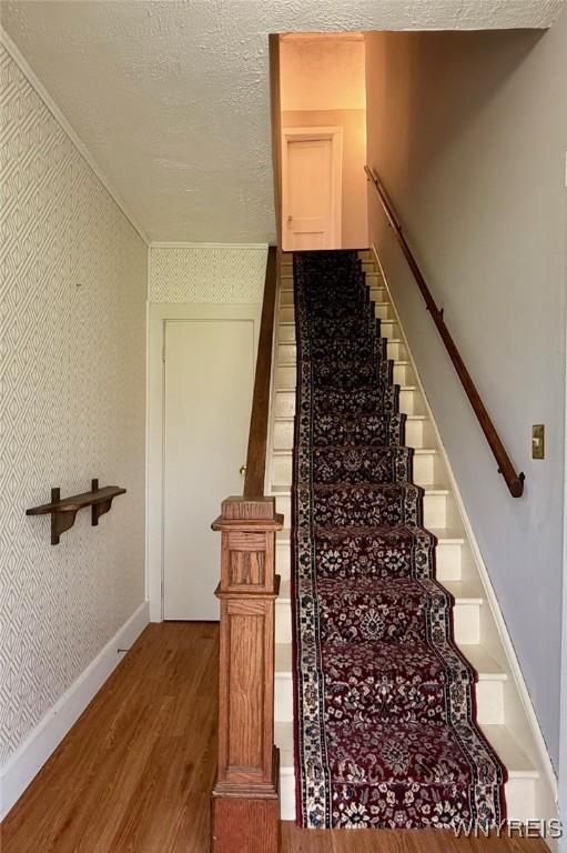 stairway featuring baseboards and wood finished floors