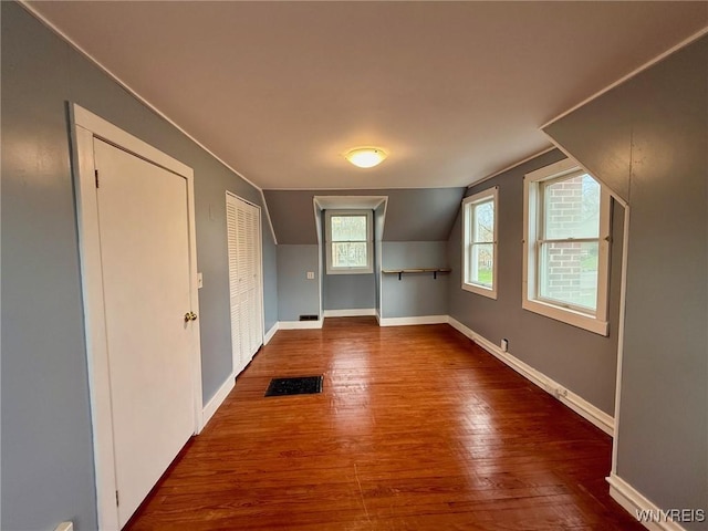unfurnished room with baseboards, wood finished floors, and lofted ceiling