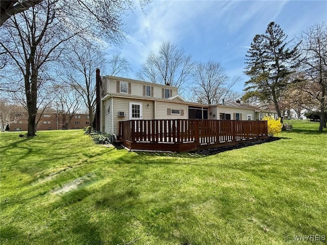 back of house featuring a yard, a chimney, and a wooden deck