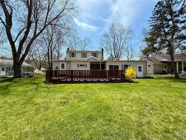 back of house featuring a wooden deck, a chimney, and a yard