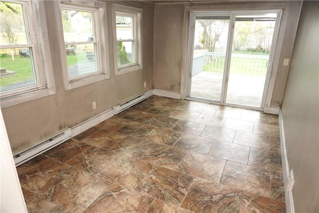 unfurnished room featuring baseboards, a baseboard radiator, and stone tile flooring