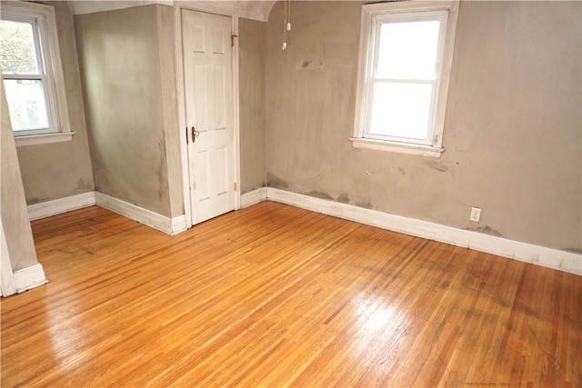 unfurnished bedroom with baseboards and light wood-style flooring