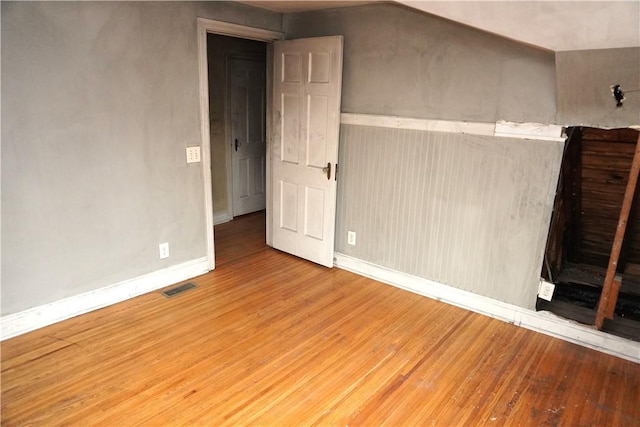 interior space featuring baseboards, wood finished floors, and visible vents