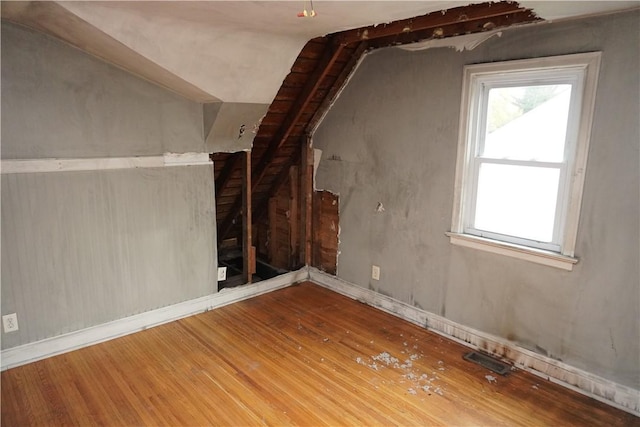 additional living space with wood finished floors and vaulted ceiling