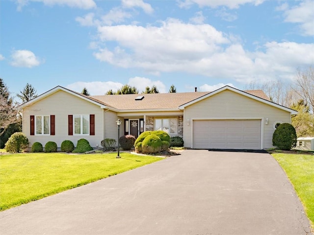 ranch-style house featuring an attached garage, driveway, and a front lawn