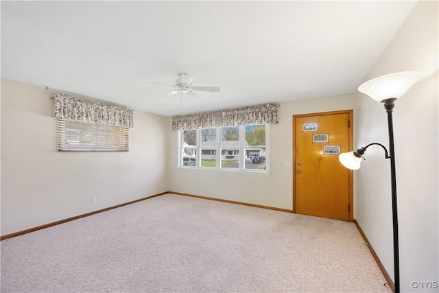 unfurnished room featuring baseboards, ceiling fan, and light carpet