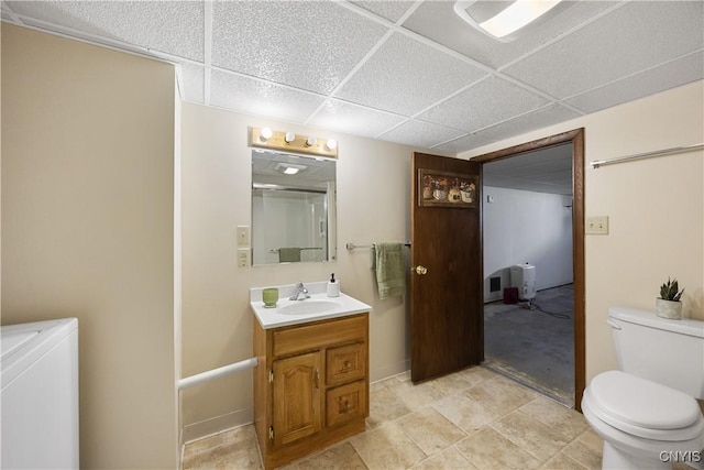 full bath with a paneled ceiling, washing machine and dryer, vanity, baseboards, and toilet