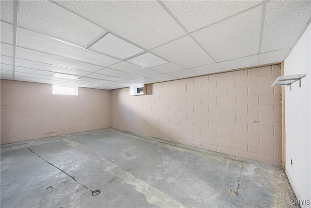 below grade area with concrete block wall and a drop ceiling