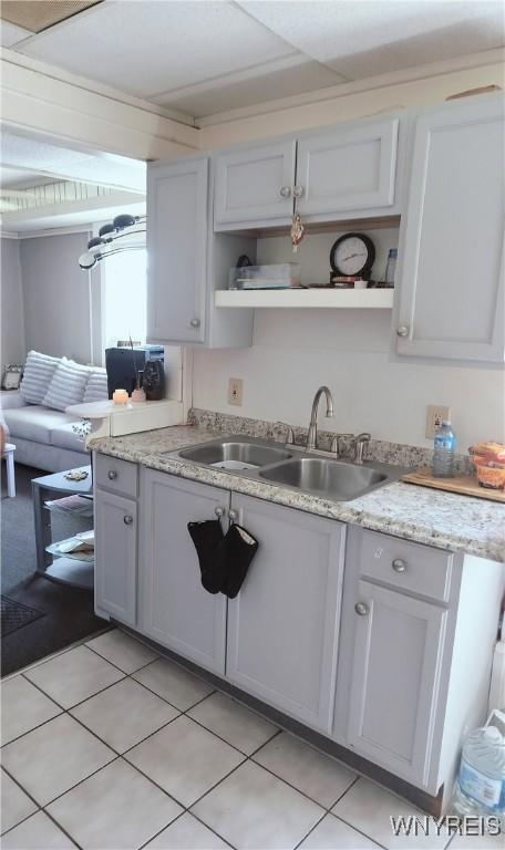 kitchen with open shelves, a sink, and light tile patterned floors