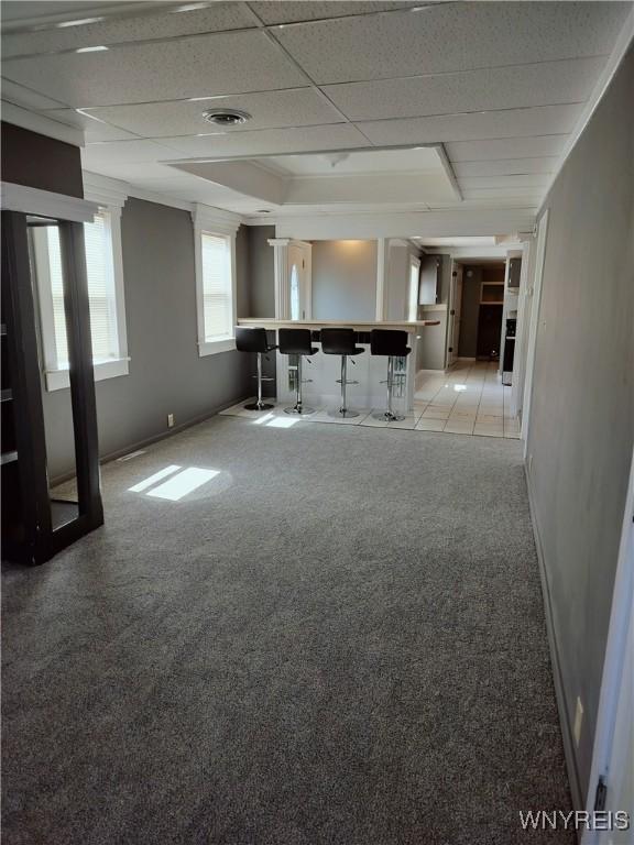 interior space featuring visible vents, a paneled ceiling, and baseboards