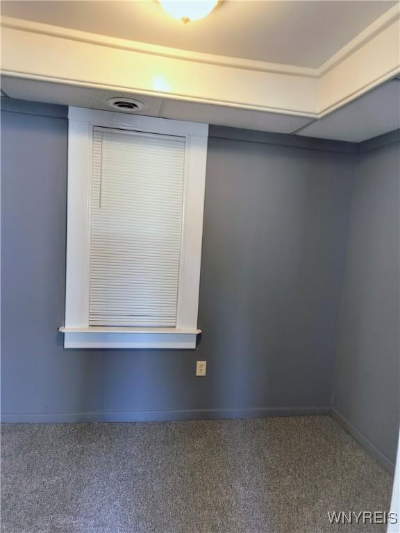 carpeted empty room featuring baseboards
