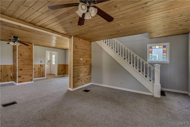 11931 State Route 12e, Lyme, NY 13622 - unfurnished living room with a ceiling fan, wood ceiling, carpet, stairway, and wooden walls