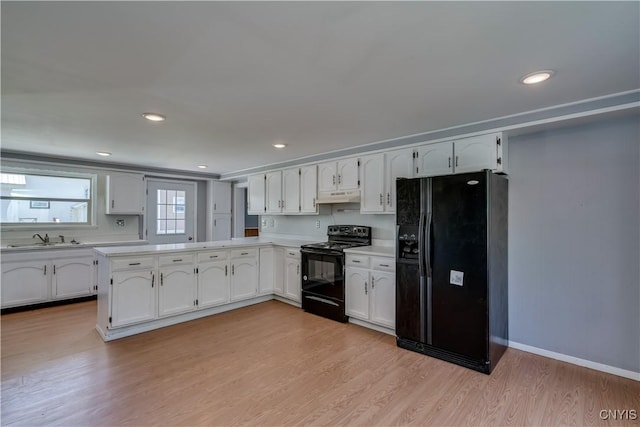 11931 State Route 12e, Lyme, NY 13622 - kitchen with black appliances, white cabinets, under cabinet range hood, light countertops, and recessed lighting