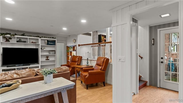living room featuring recessed lighting, light wood-style flooring, and stairway