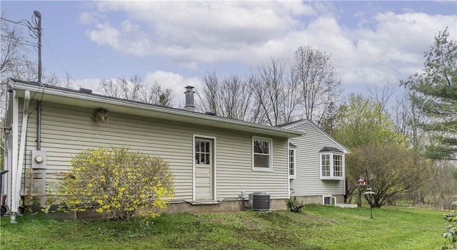 rear view of house with a lawn and central AC
