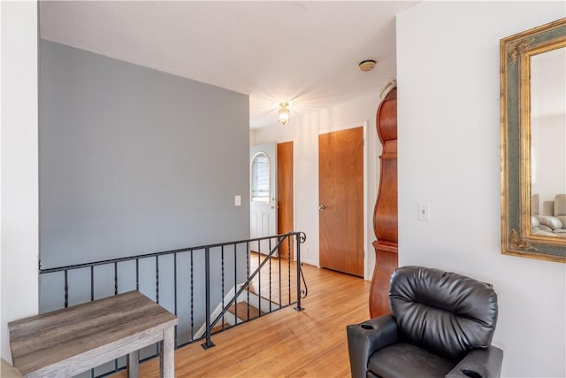 living area with an upstairs landing and light wood-style floors