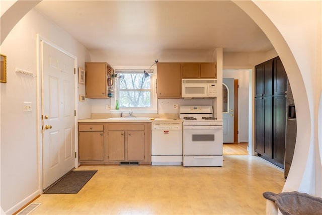 kitchen with visible vents, white appliances, light floors, light countertops, and a sink