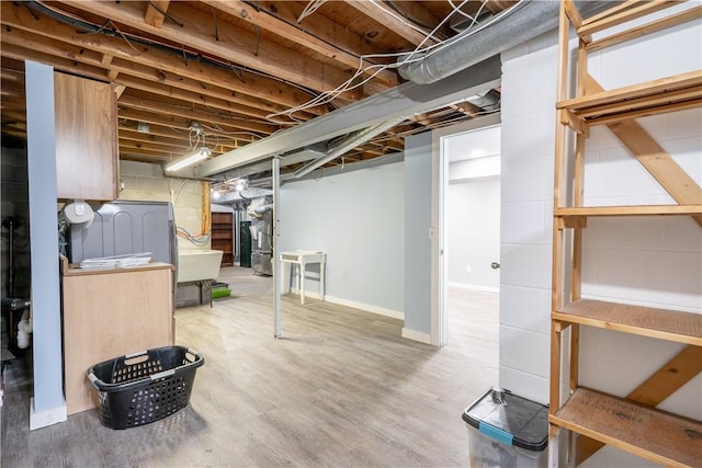 basement featuring baseboards and wood finished floors