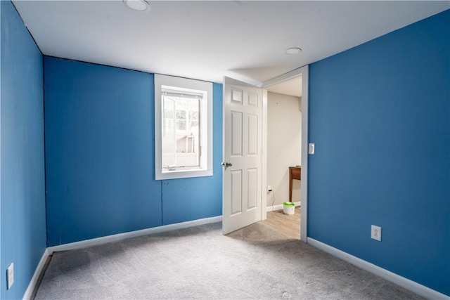 carpeted spare room featuring baseboards