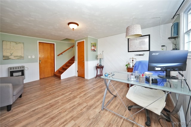 home office featuring heating unit, wood finished floors, and a wainscoted wall