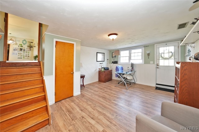 interior space featuring baseboards, visible vents, stairway, and light wood-style floors