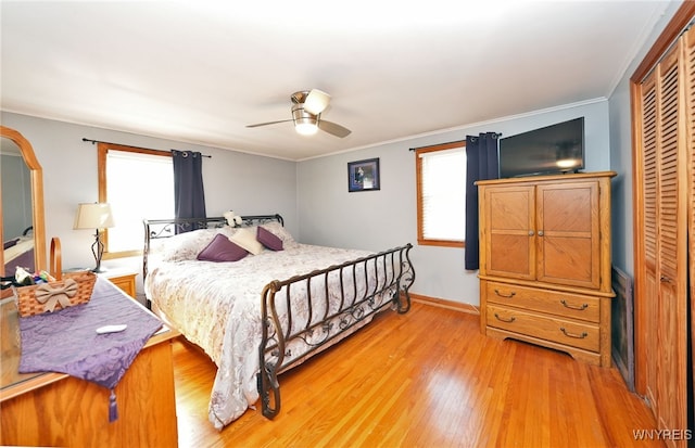 bedroom featuring multiple windows, ornamental molding, a closet, and light wood-style flooring
