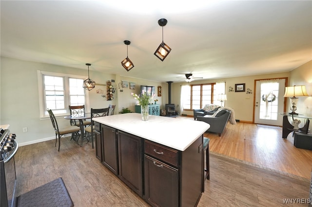 kitchen featuring black gas range, a wood stove, plenty of natural light, and wood finished floors