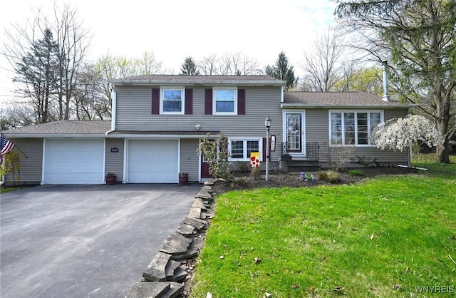 tri-level home featuring a front lawn and aphalt driveway