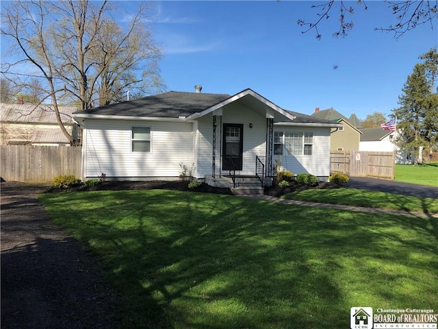 view of front of house featuring fence and a front yard