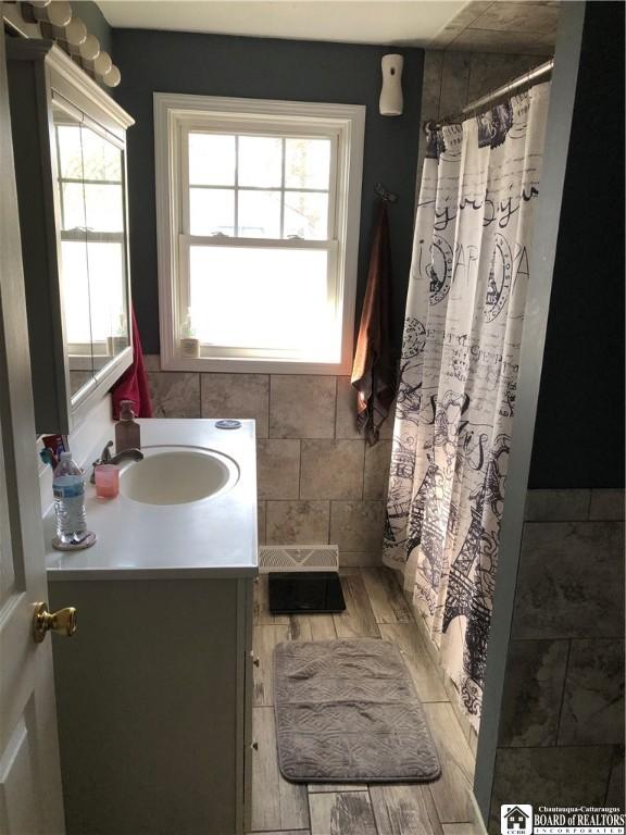 full bath with curtained shower and vanity