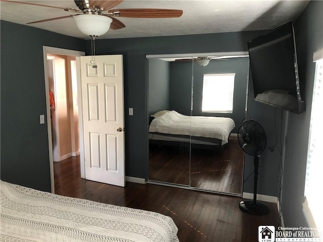 bedroom with a ceiling fan, baseboards, and hardwood / wood-style flooring