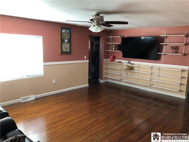 living area featuring baseboards, a ceiling fan, wood finished floors, and visible vents