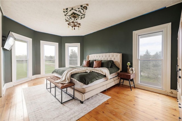 bedroom with light wood finished floors and a textured ceiling