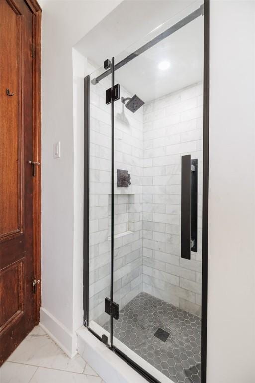 bathroom with baseboards, a shower stall, and marble finish floor