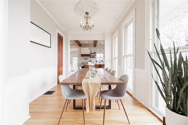 dining space featuring an inviting chandelier and light wood-style flooring