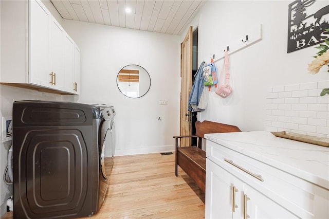 washroom featuring wood ceiling, light wood-type flooring, cabinet space, baseboards, and separate washer and dryer
