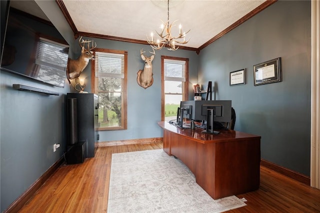 office space featuring crown molding, baseboards, wood finished floors, and a notable chandelier