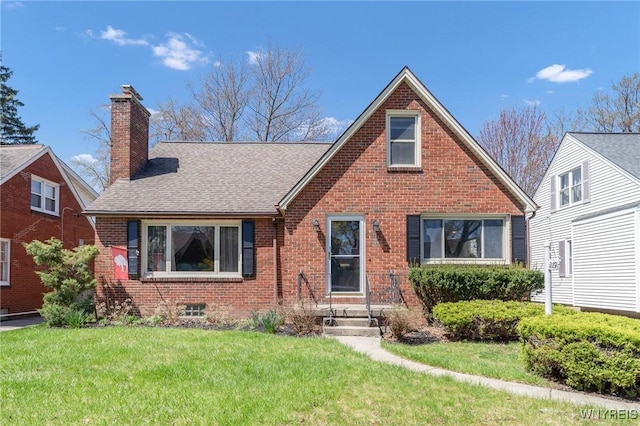 view of front facade featuring brick siding, a shingled roof, a front lawn, and a chimney
